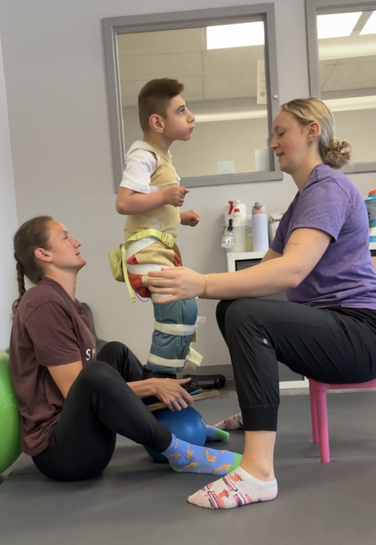 Sal practicing standing balance with two therapists